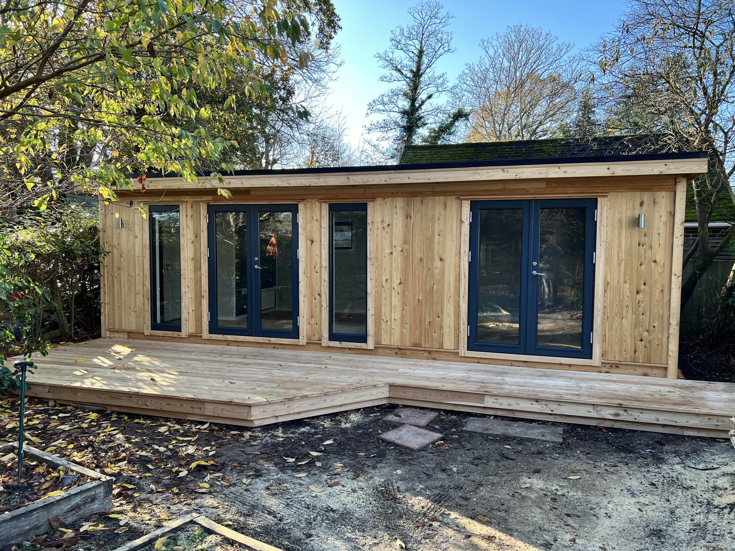 Bespoke insulated garden room with 2 sets of double doors, full length winows, exterior lights and made to measure decking.